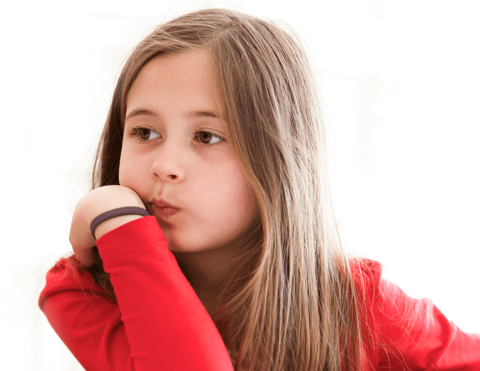 School-aged girl sitting at a table looking distractedly to the side.