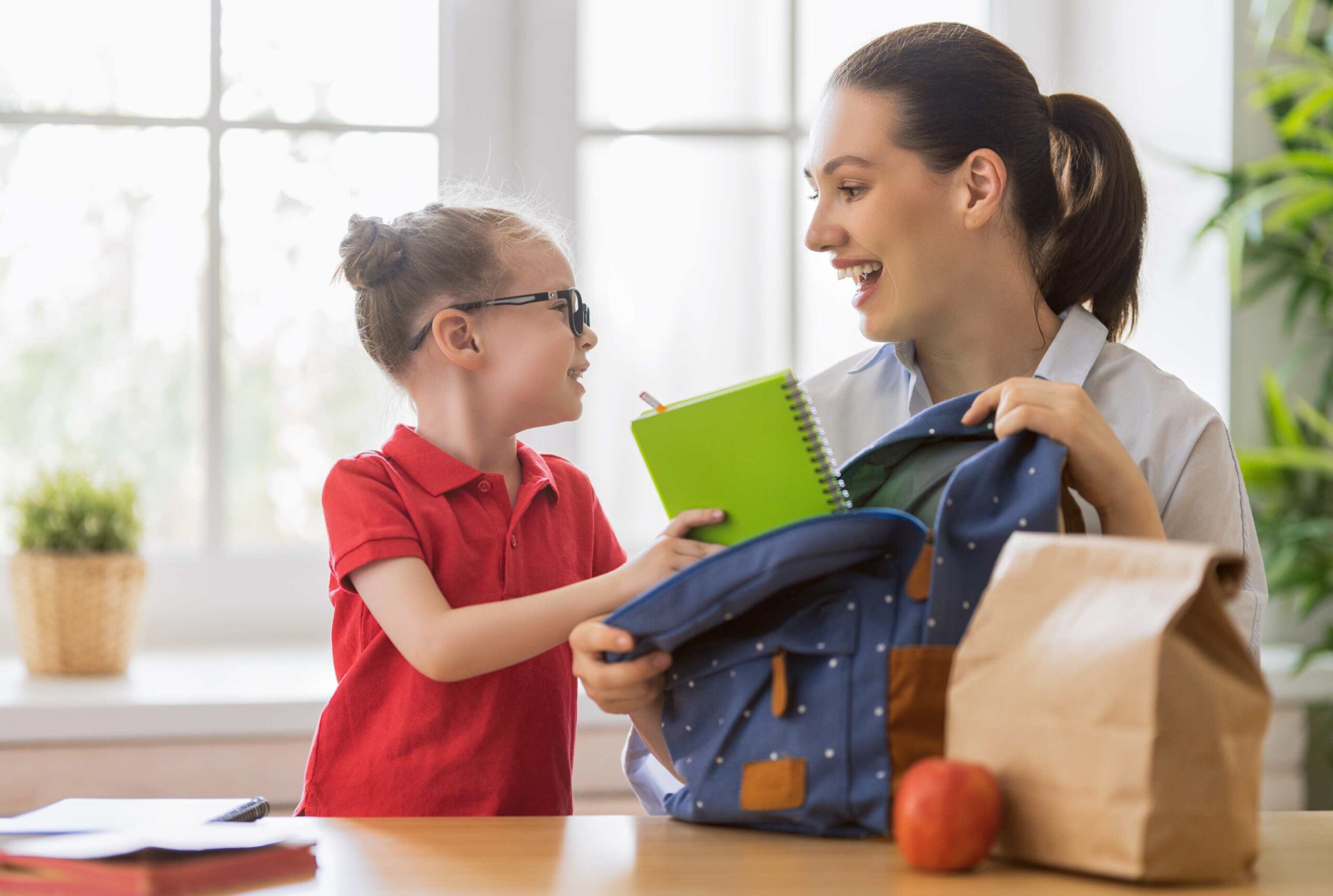 Mom and child packing a backpack for school