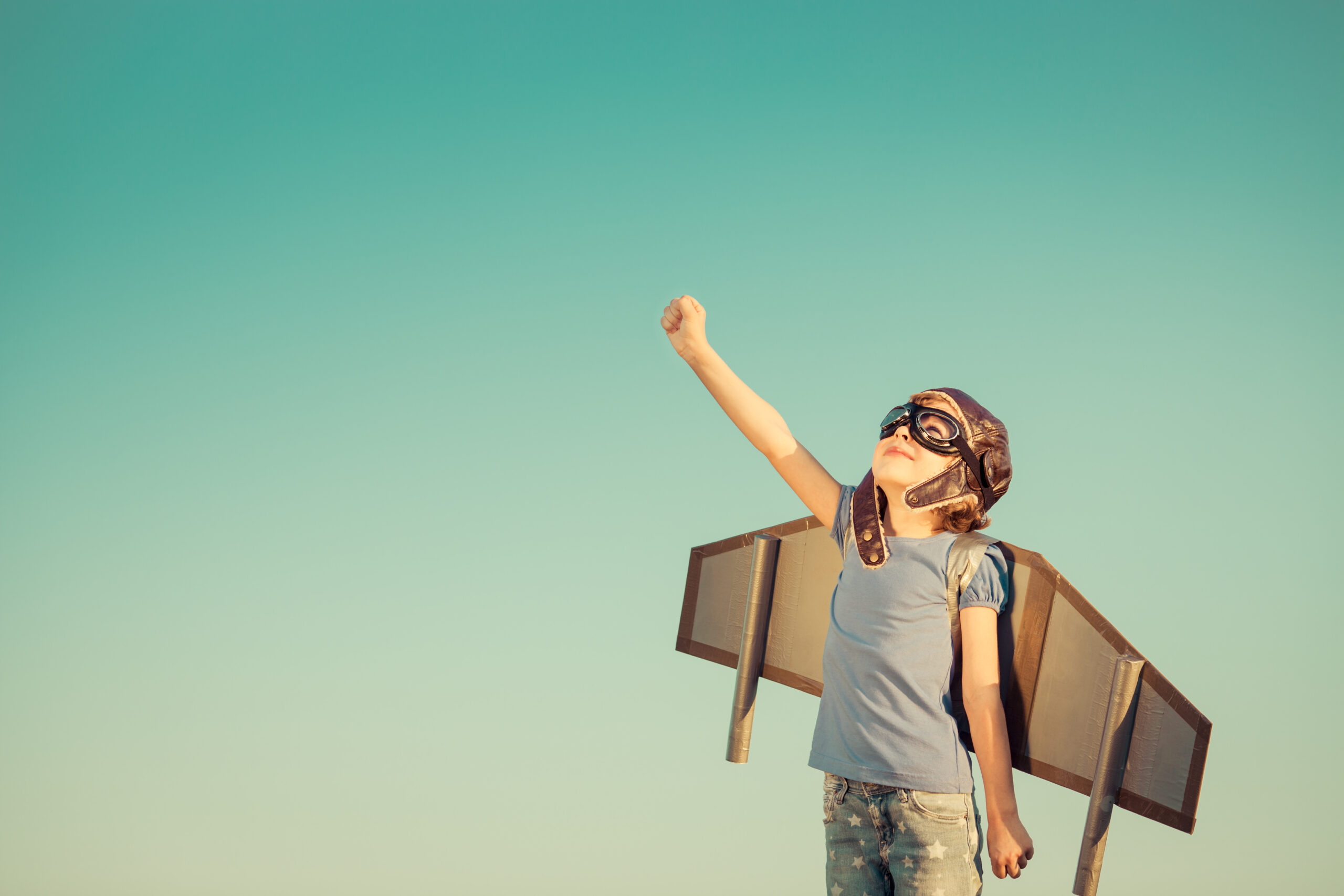 Child is wearing wings and googles as if ready to fly