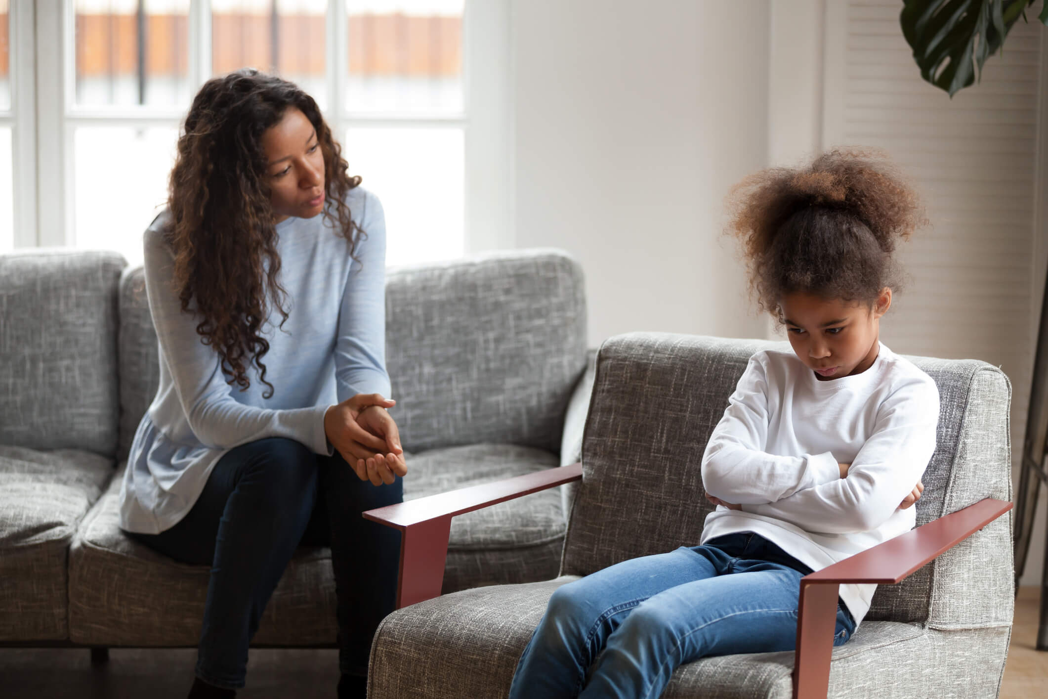 Mom is looking concerned for her daughter with arms folded